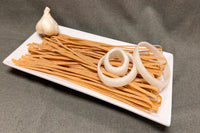 Pasta and garlic on a white plate with a gray background