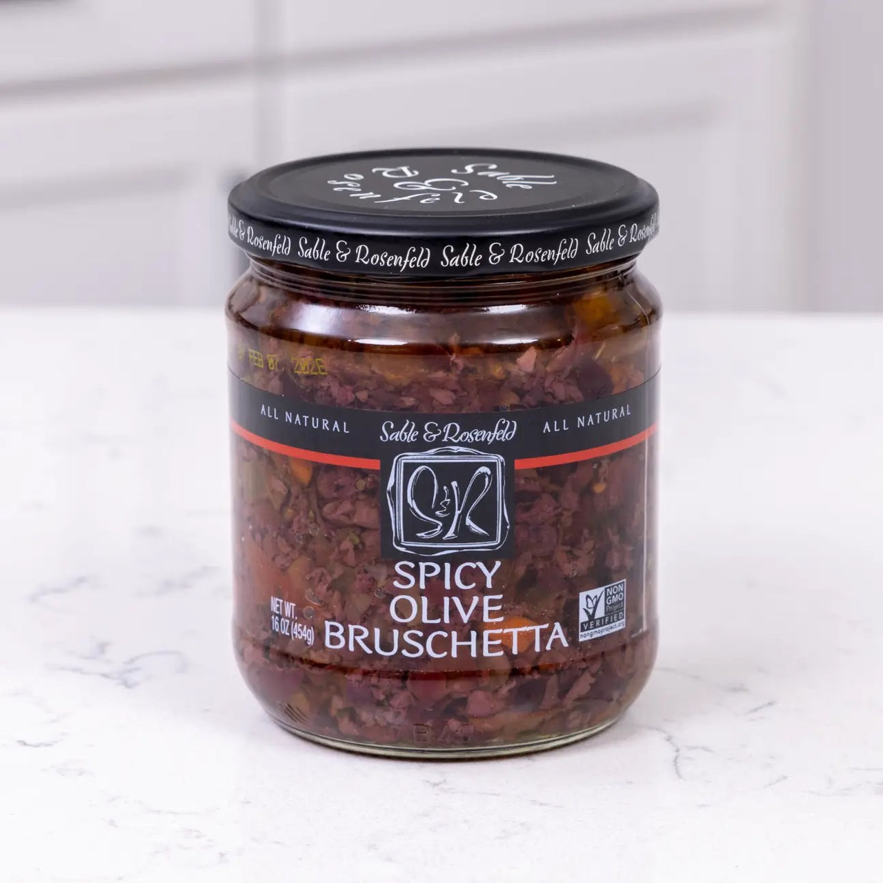 spicy olive bruschetta jar on white marble background
