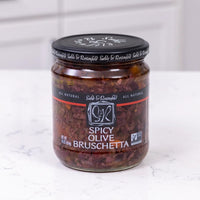 spicy olive bruschetta jar on white marble background