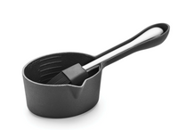 Black saucepan with a spatula on a white background